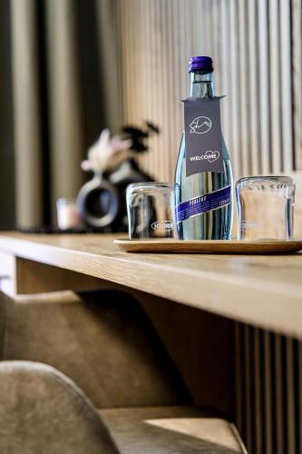 a bottle of water sitting on a table with two glasses at Hotel Salzburgerhof in Flachau