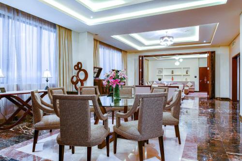 a dining room with a table with chairs and flowers at Grand Millennium Tabuk in Tabuk