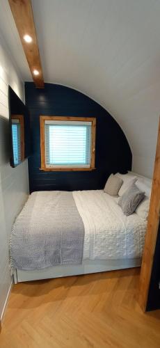 a bedroom with a large bed with a blue wall at little peru luxury pods and alpaca farm in Crosshill