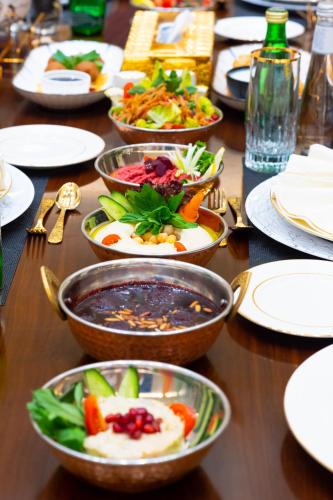 a wooden table with bowls of food on it at Grand Millennium Tabuk in Tabuk