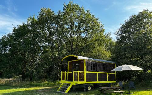 une remorque jaune avec un parapluie et une table de pique-nique dans l'établissement Domaine de la Grangée, à La Chapelle-Blanche-Saint-Martin