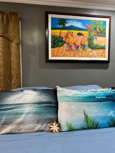 a painting hanging on a wall above a bed at Lovely Bedroom in Lila, Bohol with WIFI, AC and Ref in Lila