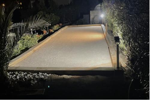 un trottoir en béton avec une lumière dessus la nuit dans l'établissement Appartement 4 pers avec terrasse et piscine, à Bormes-les-Mimosas