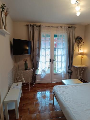 - une chambre avec un lit, une télévision et une fenêtre dans l'établissement Appartement 4 pers avec terrasse et piscine, à Bormes-les-Mimosas