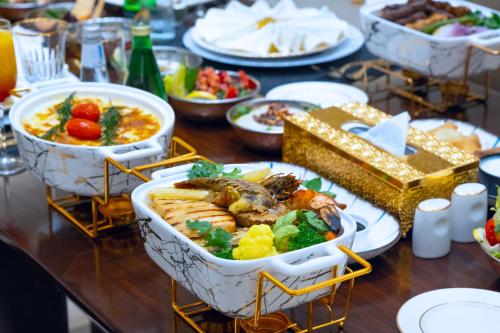 a table with many dishes of food on it at Grand Millennium Tabuk in Tabuk