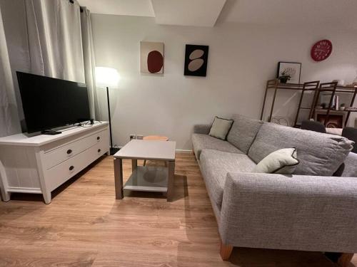 a living room with a couch and a tv at City Apartment with SKY Tower view in Auckland