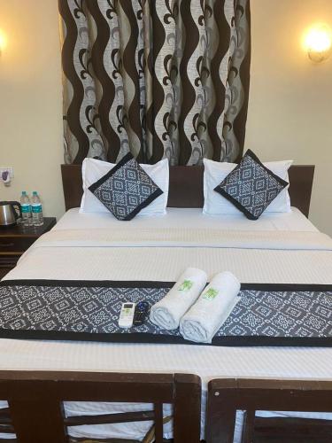 a hotel room with a bed with two pillows at Baga Beach Palms in Baga
