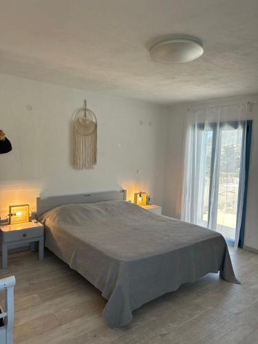 a bedroom with a large bed and a large window at Olive House in Márpissa