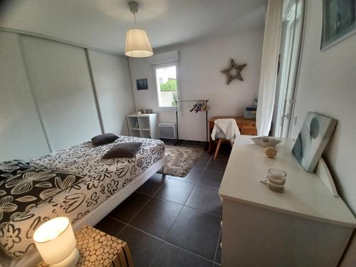 une chambre avec un lit et une table dedans dans l'établissement L'isle sur la sorgue, appartement 2 pièces jardin parking, à LʼIsle-sur-la-Sorgue