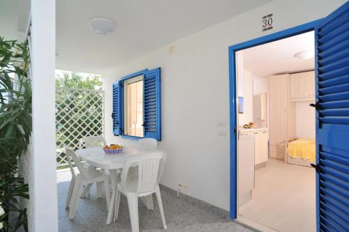 a kitchen and dining room with a table and chairs at Residence Le Orchidee in Vieste