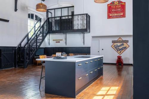 a kitchen with a island in a room with a staircase at The Great Hall, Edwinstowe Hall in Edwinstowe