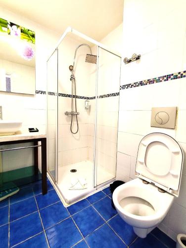 a bathroom with a shower and a toilet and a sink at Hôtel du Fort in Meulan