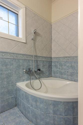 a bathroom with a tub with a shower in it at LDV ZANTE VILLAS - Luxury Dream Villa in Pandokrátor