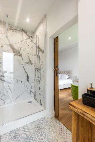 a bathroom with a walk in shower next to a glass door at Nuit magique au château de Saint Vitu 101 in Tinlot