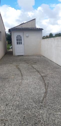 un garage blanc avec une porte blanche et une clôture dans l'établissement studio entre mer et terre, à Rétaud