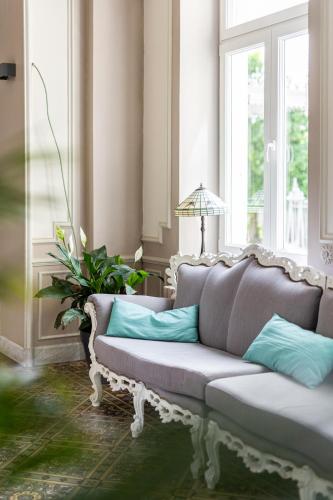 a couch with pillows in a room with a window at Nuit magique au château de Saint Vitu 101 in Tinlot