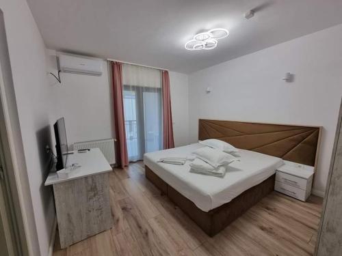 a bedroom with a bed and a desk with a television at Pensiunea Maty in Băile Herculane