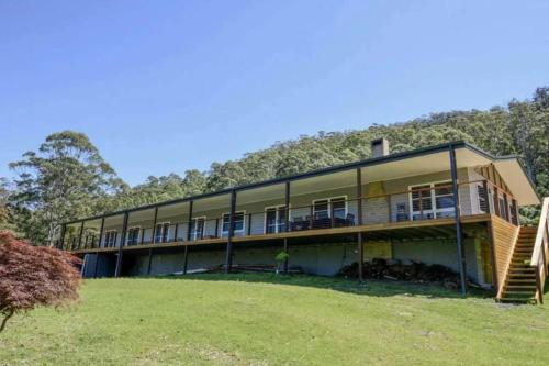 a large building with a hill in the background at Budgong Lodge - Kangaroo Valley in Kangaroo Valley