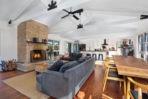 a living room with a couch and a fireplace at Budgong Lodge - Kangaroo Valley in Kangaroo Valley