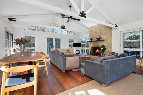 a living room with two couches and a fireplace at Budgong Lodge - Kangaroo Valley in Kangaroo Valley