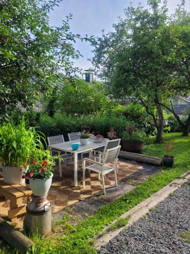 a garden with a table and chairs and plants at Guesthouse Onnia, kattohuoneisto Siurossa in Siuro