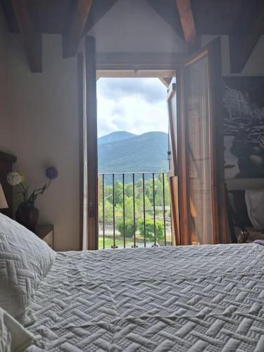a bedroom with a bed and a window with a view at Apartamento Amatista en Broto in Broto
