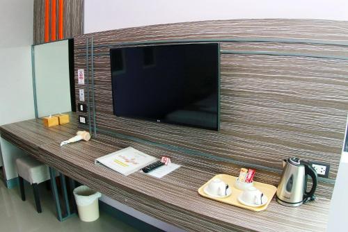 a room with a tv and a table with a tray at Arthitaya Green Nature Hotel & Lakkhana Poolside Resort in Pattaya North