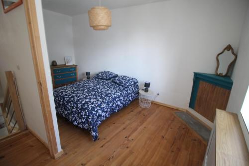 une chambre avec un lit et un parquet dans l'établissement Maison de famille 8 personnes, à Étel