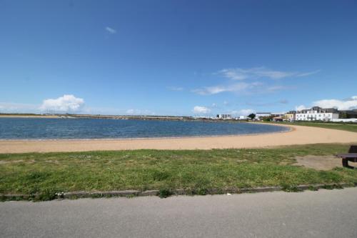 - un banc à côté d'une plage dans l'établissement Maison de famille 8 personnes, à Étel