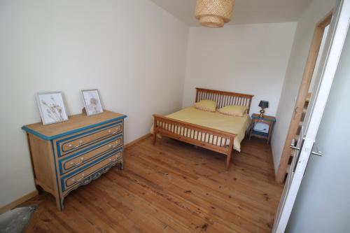 une chambre avec un lit, une commode et une table dans l'établissement Maison de famille 8 personnes, à Étel