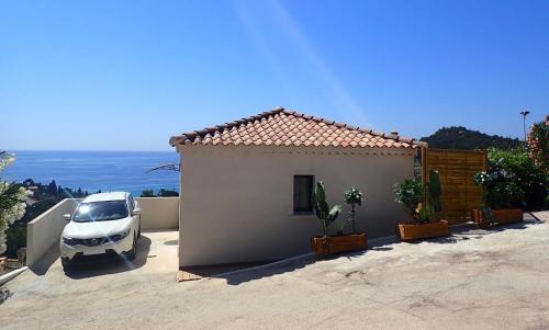 Un coche blanco aparcado delante de una casa en Villa Azur, en Le Lavandou