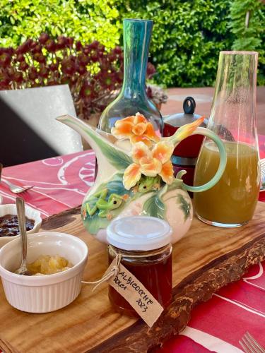 a wooden table with a vase and a jar of honey at La Beata Giovanna in Mesagne