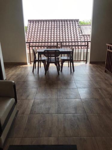 una mesa y sillas en una habitación con balcón en Villa Makmur, en Kerobokan