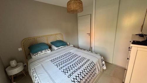 une chambre avec un lit avec des oreillers bleus dessus dans l'établissement Chez Fadel & Marjorie, à Montpellier