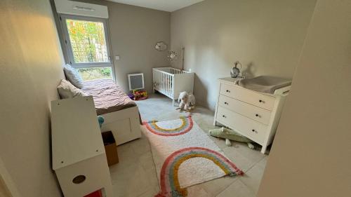 - une chambre avec un lit, un lit bébé et une fenêtre dans l'établissement Chez Fadel & Marjorie, à Montpellier