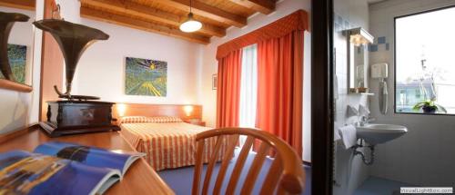 a room with a bedroom with a bed and a table at Hotel Da Bepi in Lido di Jesolo