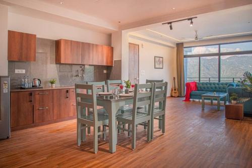 カソーリにあるThe Whispering Heights Luxury Pent Houseのテーブルと椅子のあるキッチンとリビングルーム