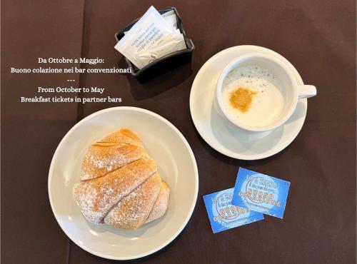 a table with two plates of bread and a cup of coffee at B&B a due passi dal mare in Caulonia Marina