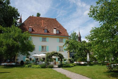 a large white building with a red roof at Schloss Ueberstorf - Tafeln, Tagen, Träumen in Ueberstorf