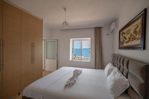 una camera da letto con un letto e un asciugamano sopra di Geart Apartments a Sarandë