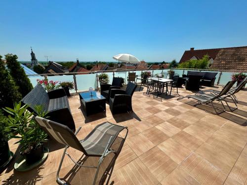 a patio with chairs and tables on a roof at Pension Seeblick in Mörbisch am See