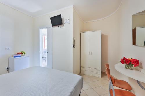 a bedroom with a bed and a table and a tv at Camping Village Le Calanchiole in Capoliveri