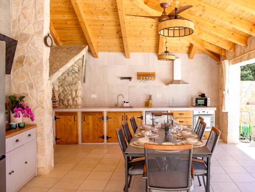 a kitchen with a table and chairs and wooden ceilings at Holiday home Bevanda in Velika Čista