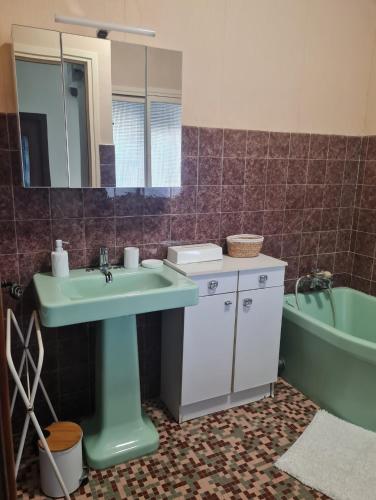 a bathroom with a sink and a mirror and a tub at Maison atypique in Tende