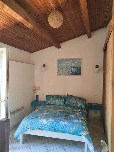 une chambre avec un lit et un plafond en bois dans l'établissement Blue Corniche à 3 mn à pied de la plage, à Sète