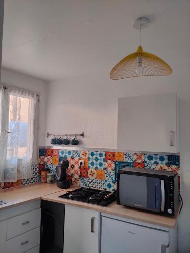 une cuisine avec un comptoir avec un micro-ondes dans l'établissement Blue Corniche à 3 mn à pied de la plage, à Sète