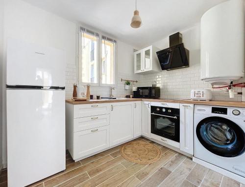 La cuisine est équipée d'un réfrigérateur blanc et d'un lave-vaisselle. dans l'établissement La petite boétie, à Sarlat-la-Canéda