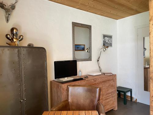une pièce avec un bureau avec un ordinateur et une chaise dans l'établissement Magnifique Studio Plein centre vue panoramique, à Chamonix-Mont-Blanc
