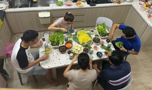 a group of people sitting around a table eating food at Sophia Healing House Cần Thơ in Can Tho