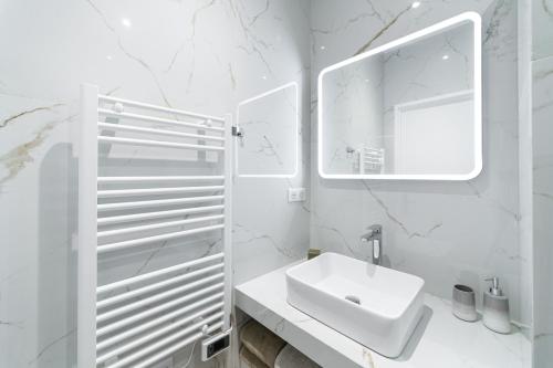 une salle de bain blanche avec un lavabo et un miroir dans l'établissement French riviera old town heart, à Nice